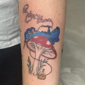 a colorful tattoo of a caterpillar smoking on a mushroom